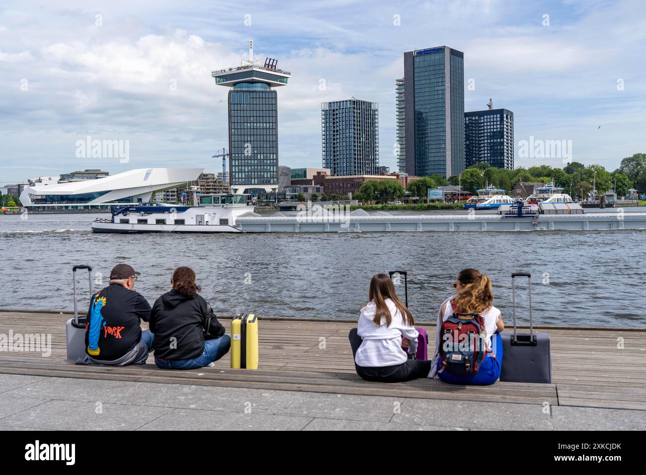 Touristen, die hinter dem Amsterdamer Hauptbahnhof sitzen, an der Promenade des Flusses Ij, A'DAM Aussichtspunkt, Wolkenkratzer, Sightseeing, hier ist Holland, Amste Stockfoto