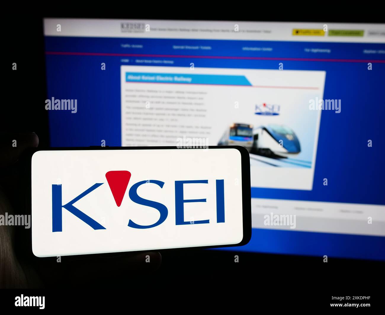 Person mit Smartphone und Logo der japanischen Eisenbahngesellschaft Keisei Electric Railway Co. Ltd. Vor der Website. Schwerpunkt auf dem Display des Telefons. Stockfoto