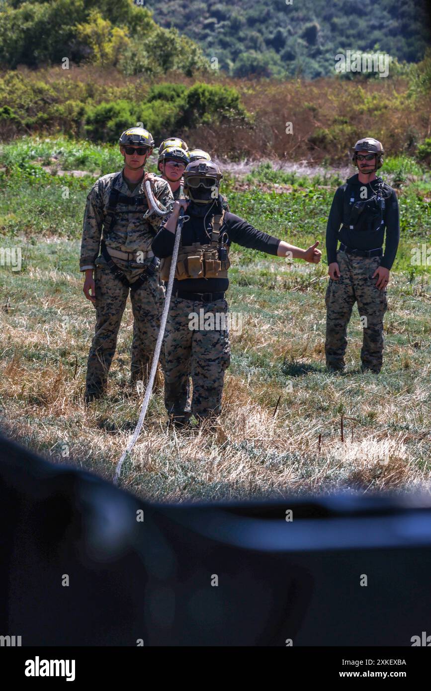 US-Soldaten bereiten sich darauf vor, von einem CH-53E Super Hengst mit der Marine Heavy Helicopter Squadron (HMH) 466, Marine Aircraft Group 16, 3rd Marine Aircraft Wing, während einer speziellen Patrouilleneinführungs- und Extraktionsübung im Marine Corps Base Camp Pendleton, Kalifornien, am 16. Juli 2024 aufgehoben zu werden. HMH-466 arbeitete mit der Expeditionary Operations Training Group I Marine Expeditionary Force zusammen, um Marines und Soldaten auszubilden, die am Helicopter Rope Suspension Techniques Masters Kurs 24-3 teilnahmen, in Techniken, die verwendet werden, um Kräfte schnell ein- und auszuziehen, wenn die Landung eines Hubschraubers nicht machbar ist. (US-Mari Stockfoto