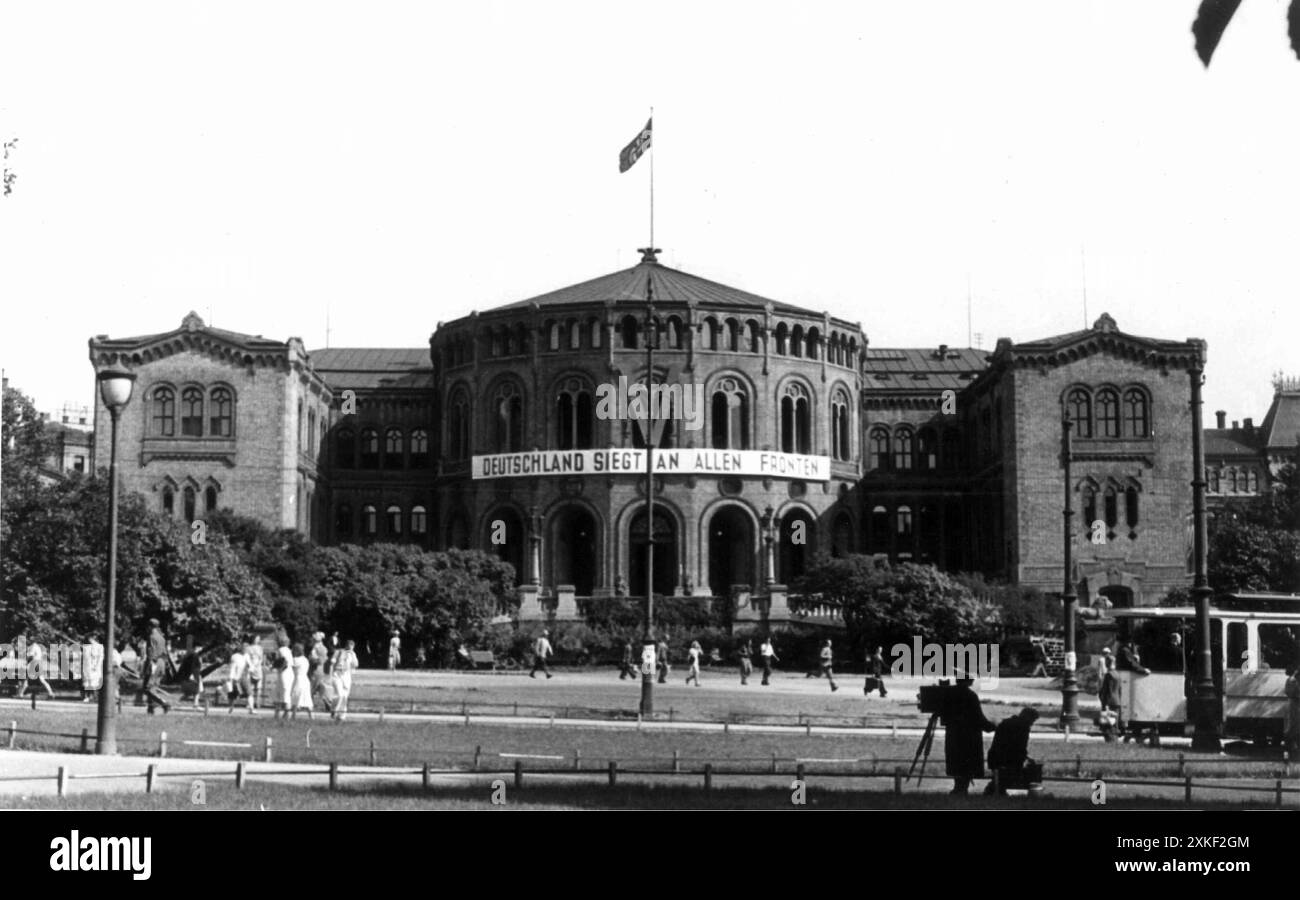 Das norwegische parlamentsgebäude (Stortingsbygningen) in Oslo im von Deutschland besetzten Norwegen während des Zweiten Weltkriegs mit einer Hakenkreuzfahne Nazi-Deutschlands auf dem Dach. Das Bild zeigt auch den deutschen Nazi-Slogan Deutschland Siegt an allen Fronten und das deutsche V-Zeichen an der Vorderseite des Gebäudes. Stockfoto