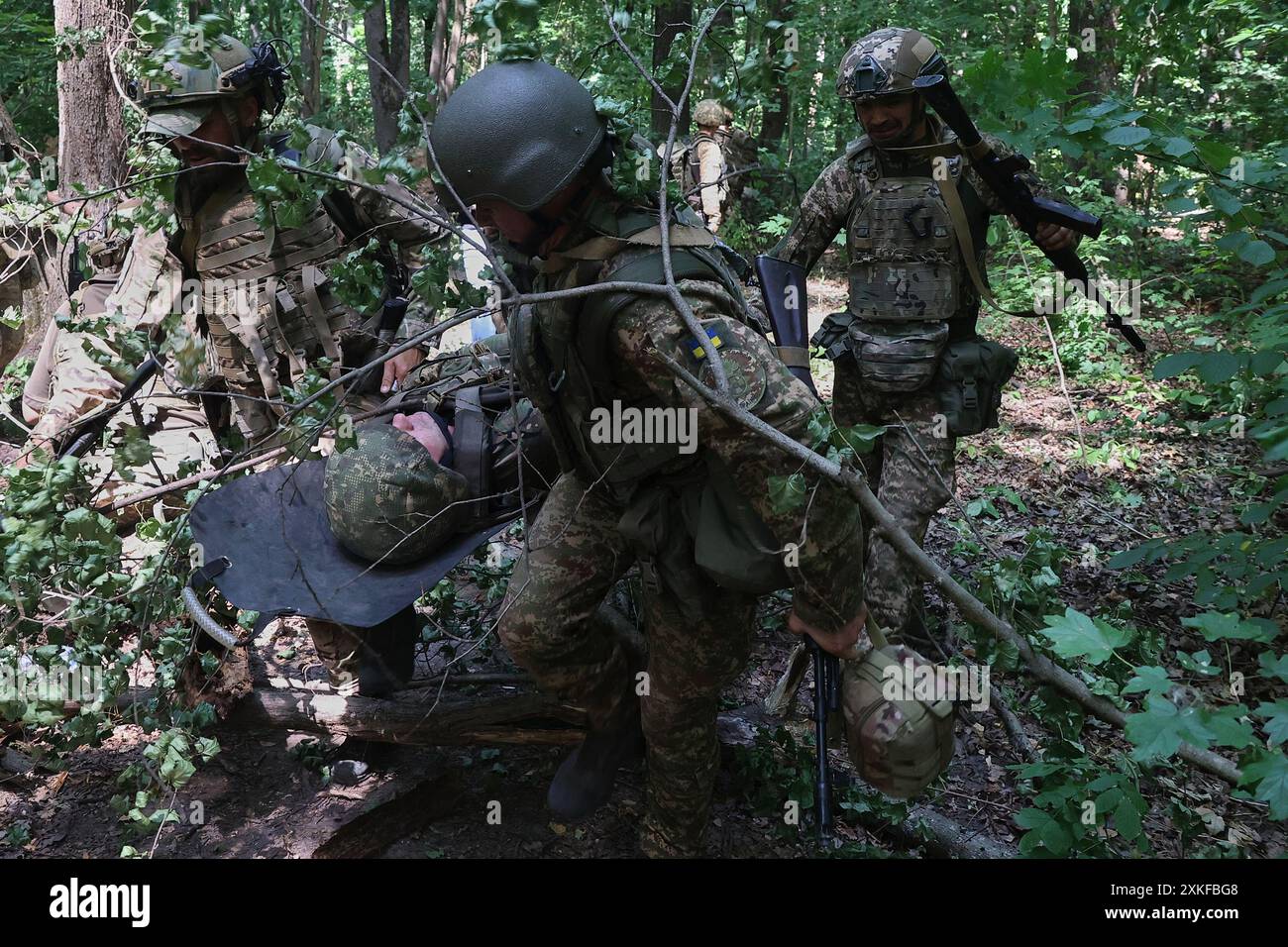 UKRAINE - 22. JULI 2024 - Soldaten der 3. Brigade des Obersten Petro Bolbochan, die die Nationalgarde der Ukraine (auch als Spartan Brigade bekannt) betreibt, während einer taktischen Übung die Evakuierung eines verwundeten Soldaten. Stockfoto