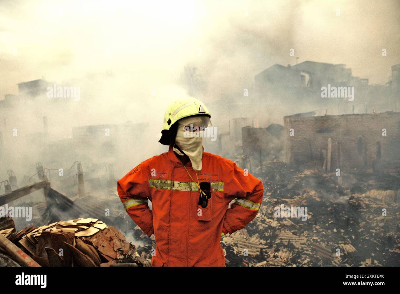 Ein Feuerwehrmann, der nach einem Feuerunfall eine Pause von der Brandbekämpfung machte, brannte Hunderte von Häusern in einer dichten Nachbarschaft in Jakarta, Indonesien, ab. Stockfoto