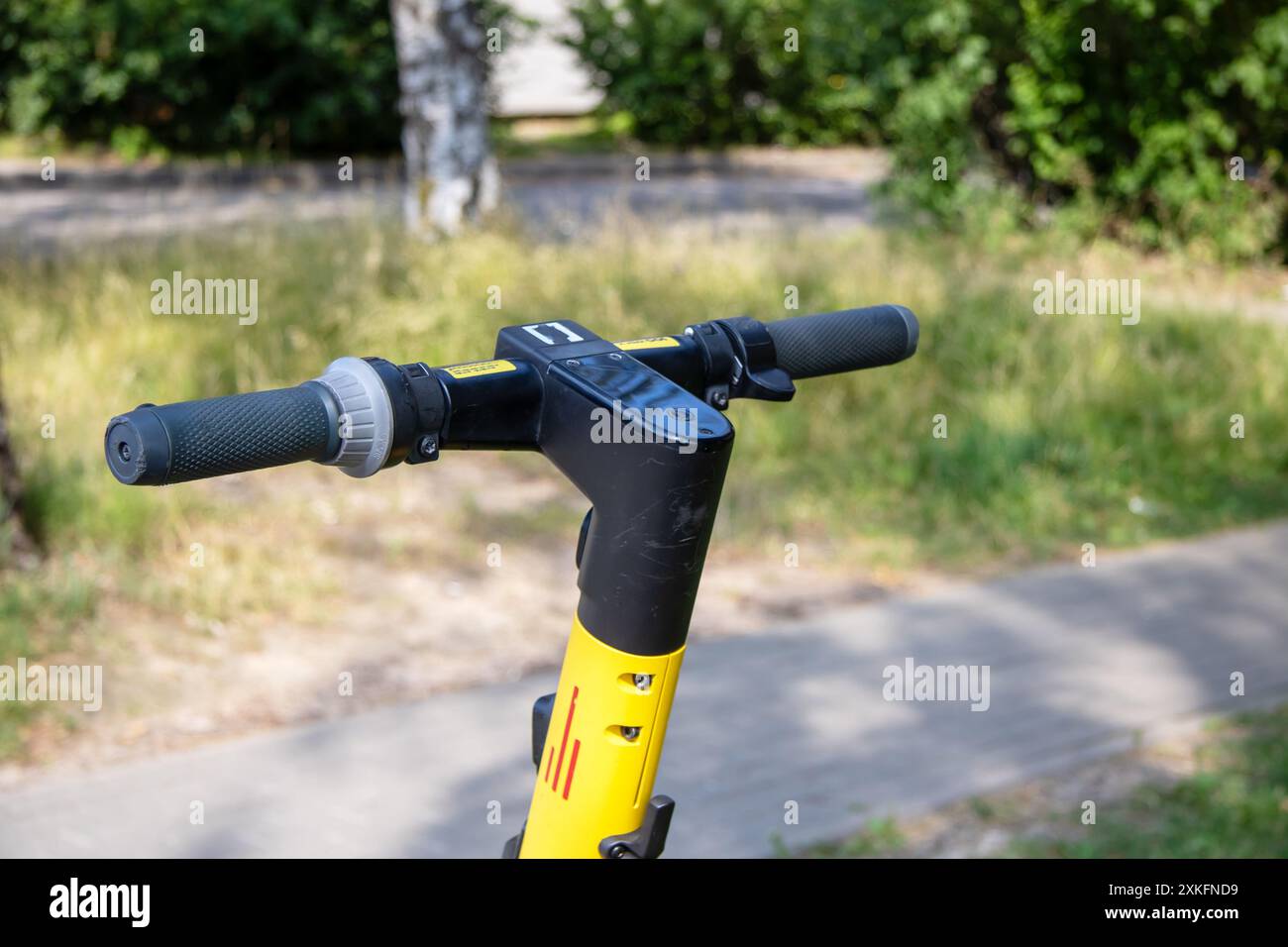 Das detailreiche Foto zeigt einen gelb-schwarzen Roller, der auf einem Bürgersteig liegt, und hebt sein Design und seine Farben hervor Stockfoto