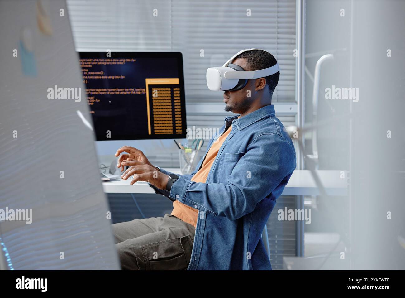 Seitenansicht eines männlichen afroamerikanischen Softwareentwicklers, der die VR-Benutzererfahrung mit VR-Headset im IT-Firmenbüro testet, Kopierraum Stockfoto