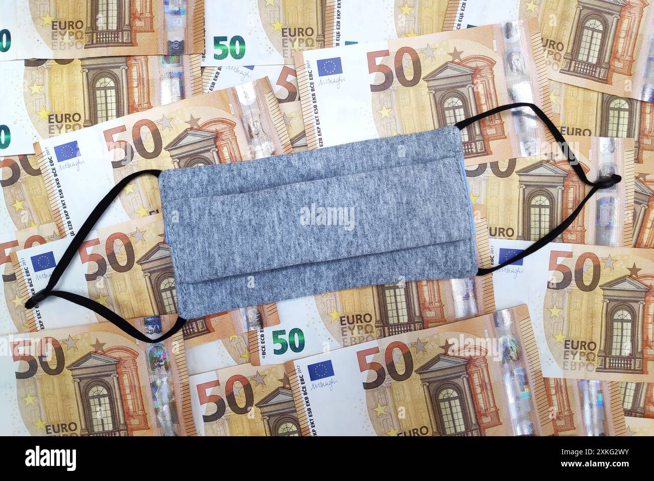 Gesichtsmaske auf einem Stapel 50-Euro-Banknoten Stockfoto