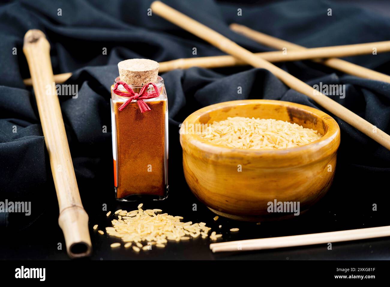 Tomatensamen in einer Holzschale und Tomatenpulver in einer Glasflasche Stockfoto