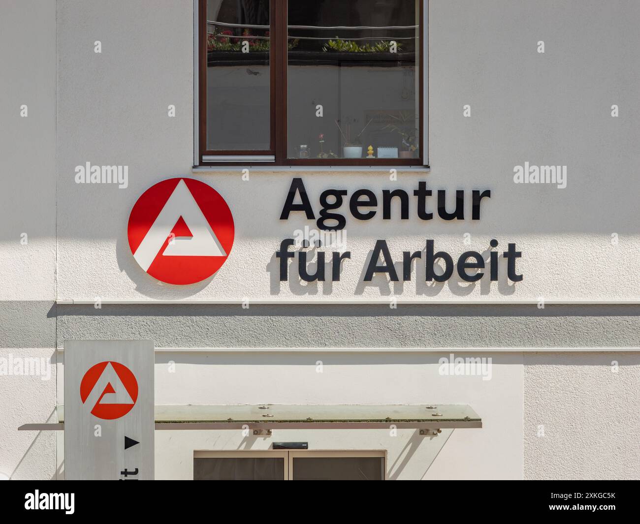 Schild der Agentur für Arbeit an der Gebäudewand. Regierungsdienst und Hilfe für Arbeitslose. Suche nach einem neuen Job. Stockfoto