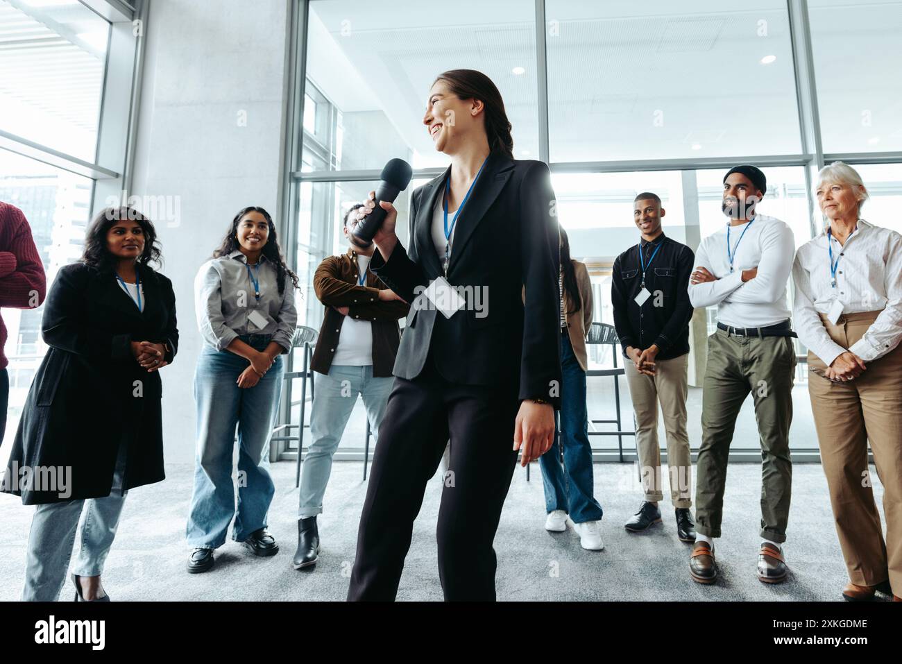 CEO spricht Mitarbeiter in einem zwanglosen Meeting mit einem vielfältigen Team in einem hellen, modernen Büroumfeld an. Stockfoto