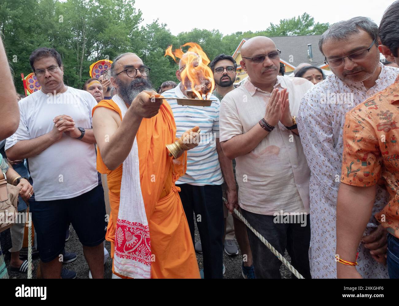 Zu Beginn der Ratha Yatra-Streitwagenprozession Swami Pandit Balgopal führt ein Hindu-Mönch das arti-Ritual des Flammenwinkens durch. In Wilton Ct., 2024. Stockfoto