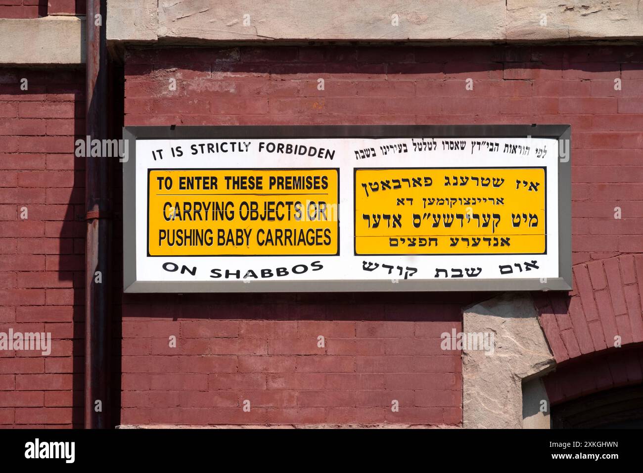 Ein englisches, jiddisches und hebräisches Schild vor einer Synagoge, das die Gläubigen daran erinnert, den Sabbat zu beobachten. In Williamsburg, Brooklyn, New York. Stockfoto