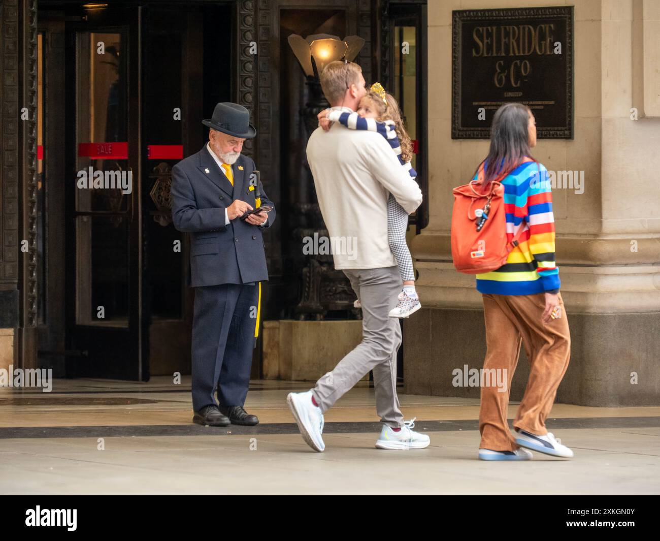 Uniformierter Türsteher begrüßt die Käufer vor Selfridges in der Oxford Street London Stockfoto