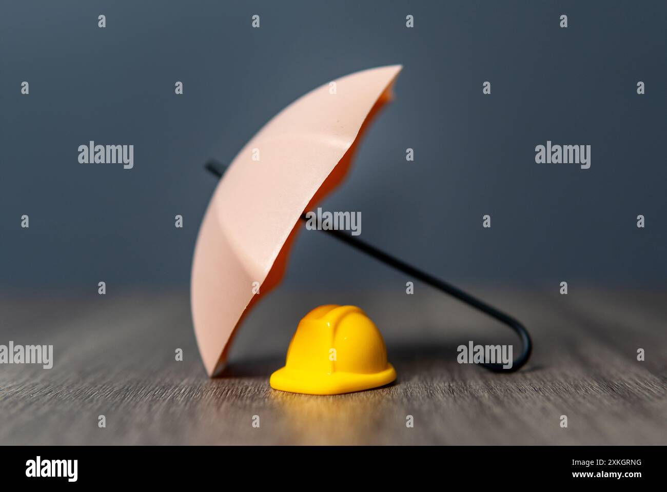 Ein gelber Schutzhelm und Regenschirm. Arbeitnehmerversicherung, Sicherheit an erster Stelle. Stockfoto