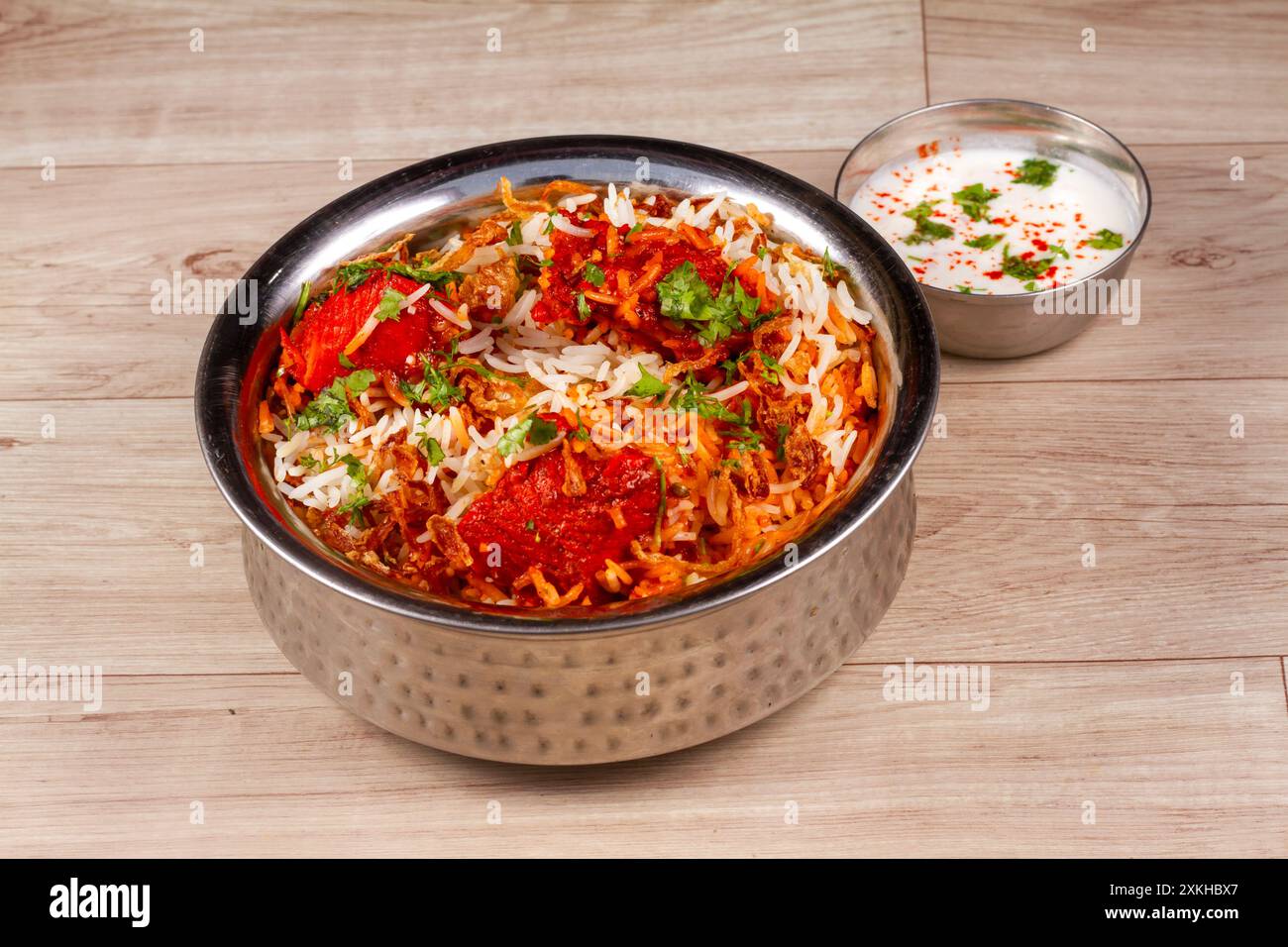 Traditionelles Huhn Dum Biryani mit gemischtem Gemüse serviert mit gemischter Raita, selektiver Fokus Stockfoto