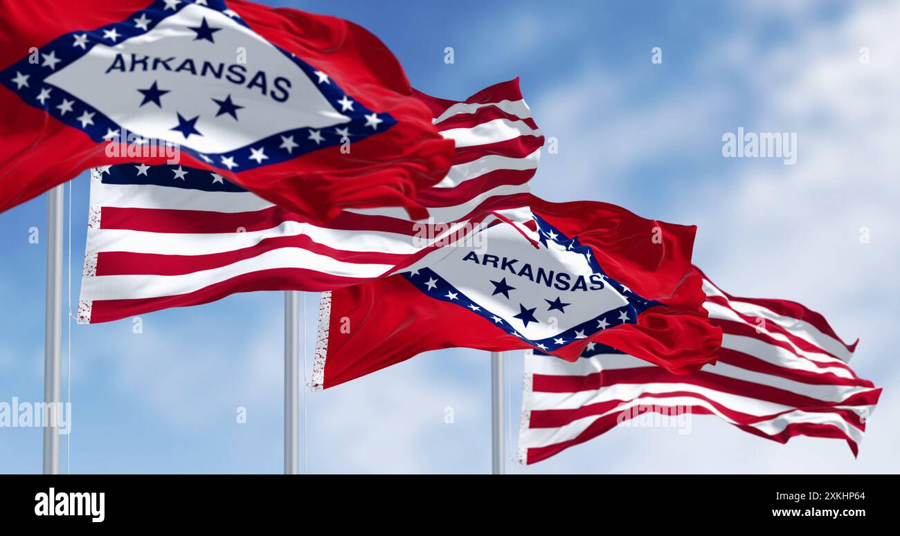 Arkansas Staatsflaggen schwenken mit den amerikanischen Flaggen an einem klaren Tag. 3D-Darstellung. Selektiver Fokus. Gewelltes Material Stockfoto