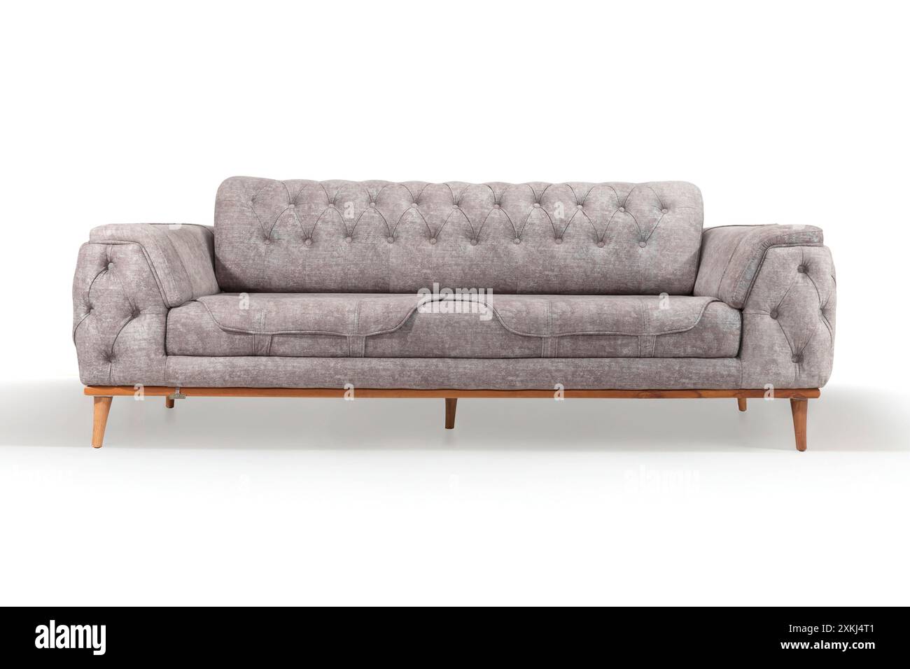 Elegantes graues Sofa mit getufteten Details, perfekt für eine elegante Wohnzimmereinrichtung. Stockfoto