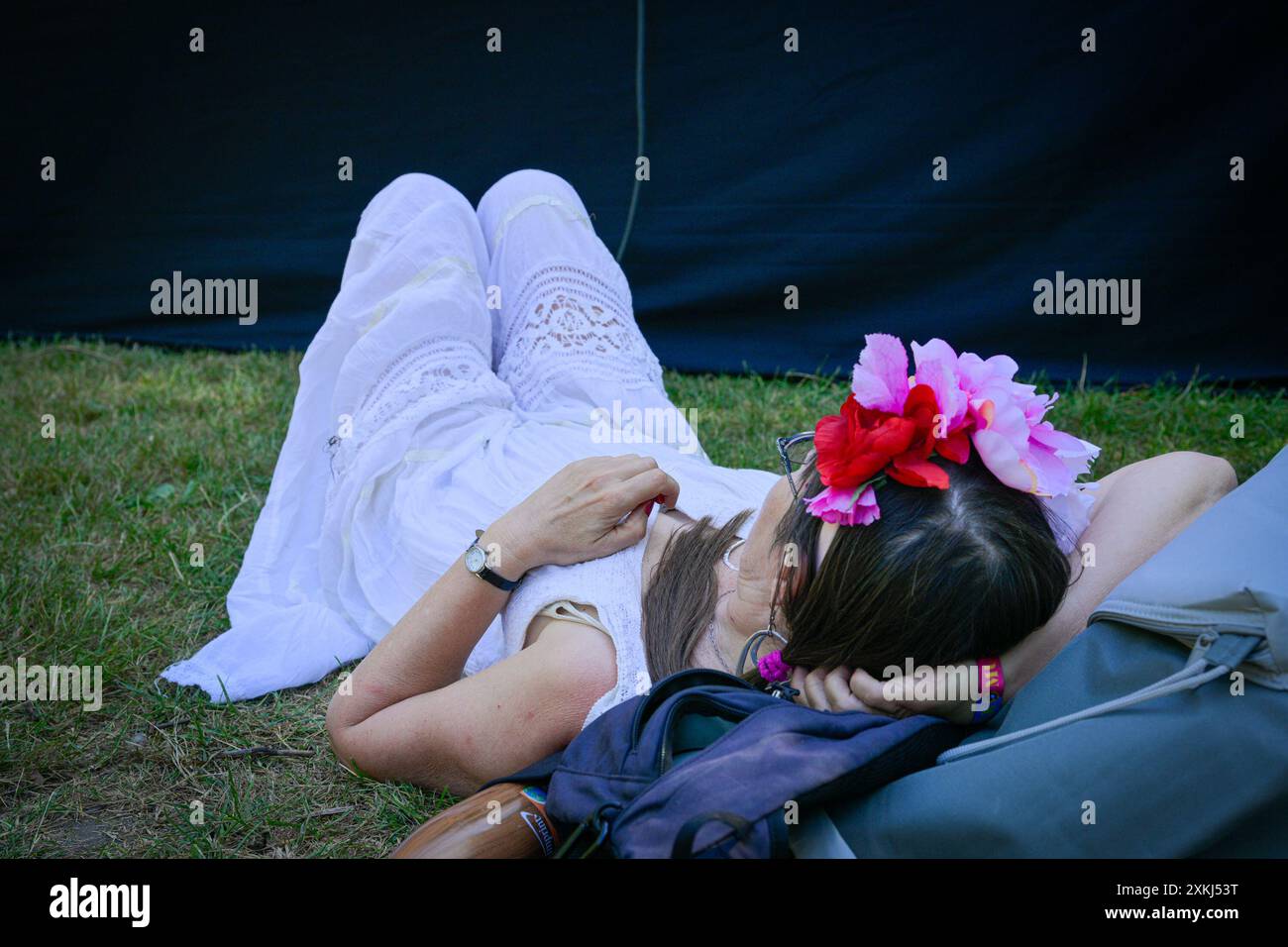 Frau mit Blumenschmuck im Haar, die ein Konzert beim Musikfestival ansieht Stockfoto