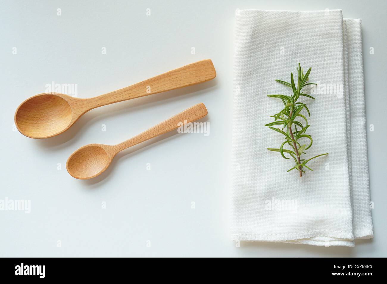 Hölzerne Reisschaufel und weißer Lappen auf weißem Hintergrund Stockfoto