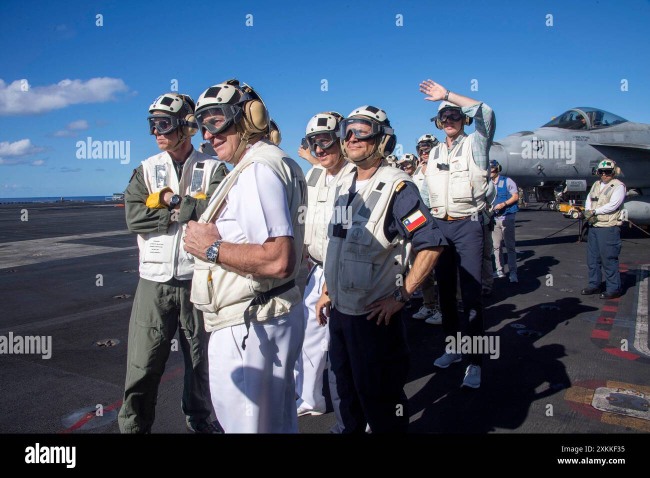 Michael Wosje, links, Kommandeur der Carrier Strike Group ONE, und Mitglieder der chilenischen Marine beobachten den Flugbetrieb auf dem Flugdeck des Flugzeugträgers USS Carl Vinson (CVN 70) der Nimitz-Klasse während der Phase der Übung Rim of the Pacific (RIMPAC) 2024 im Pazifischen Ozean am 18. Juli. 29 Nationen, 40 Überlandschiffe, drei U-Boote, 14 nationale Landstreitkräfte, mehr als 150 Flugzeuge und 25.000 Mitarbeiter nehmen vom 27. Juni bis 1. August an der RIMPAC Teil. RIMPAC ist die weltweit größte internationale Übung im Seeverkehr und bietet eine einzigartige Ausbildung Stockfoto