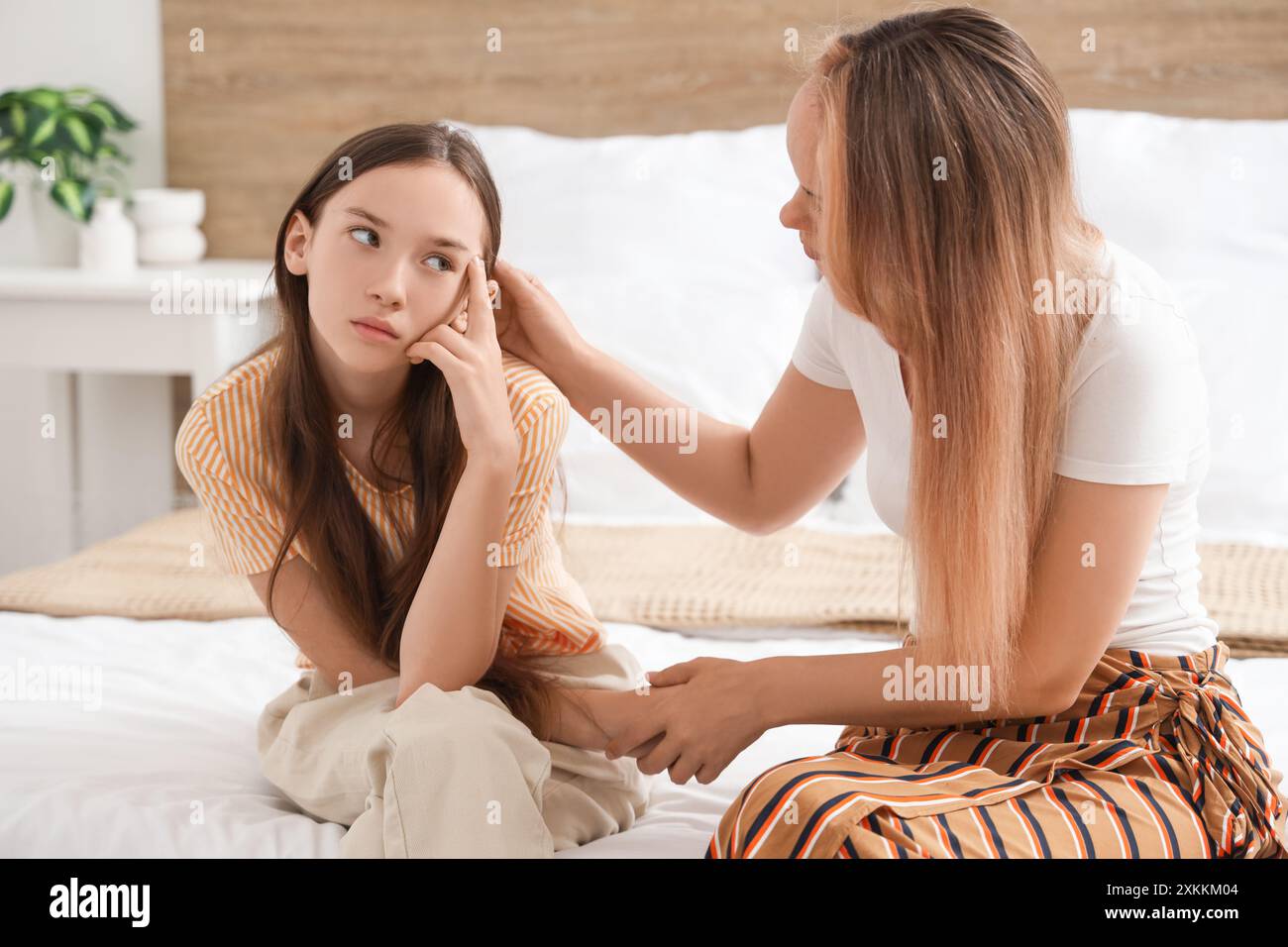 Trauriges Mädchen im Teenageralter mit ihrer Mutter im Schlafzimmer. Familienschwierigkeitskonzept Stockfoto