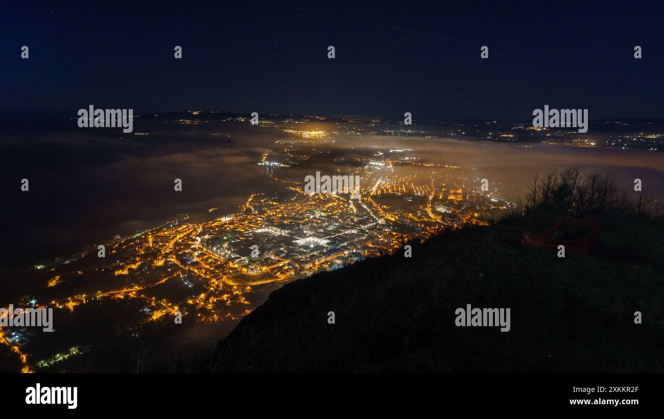 Blick über die Stadt an der mittelmeerküste vom Aussichtspunkt Monte Sant'Elia in der Abenddämmerung bei Nacht, PALMI, Kalabrien, Italien Stockfoto