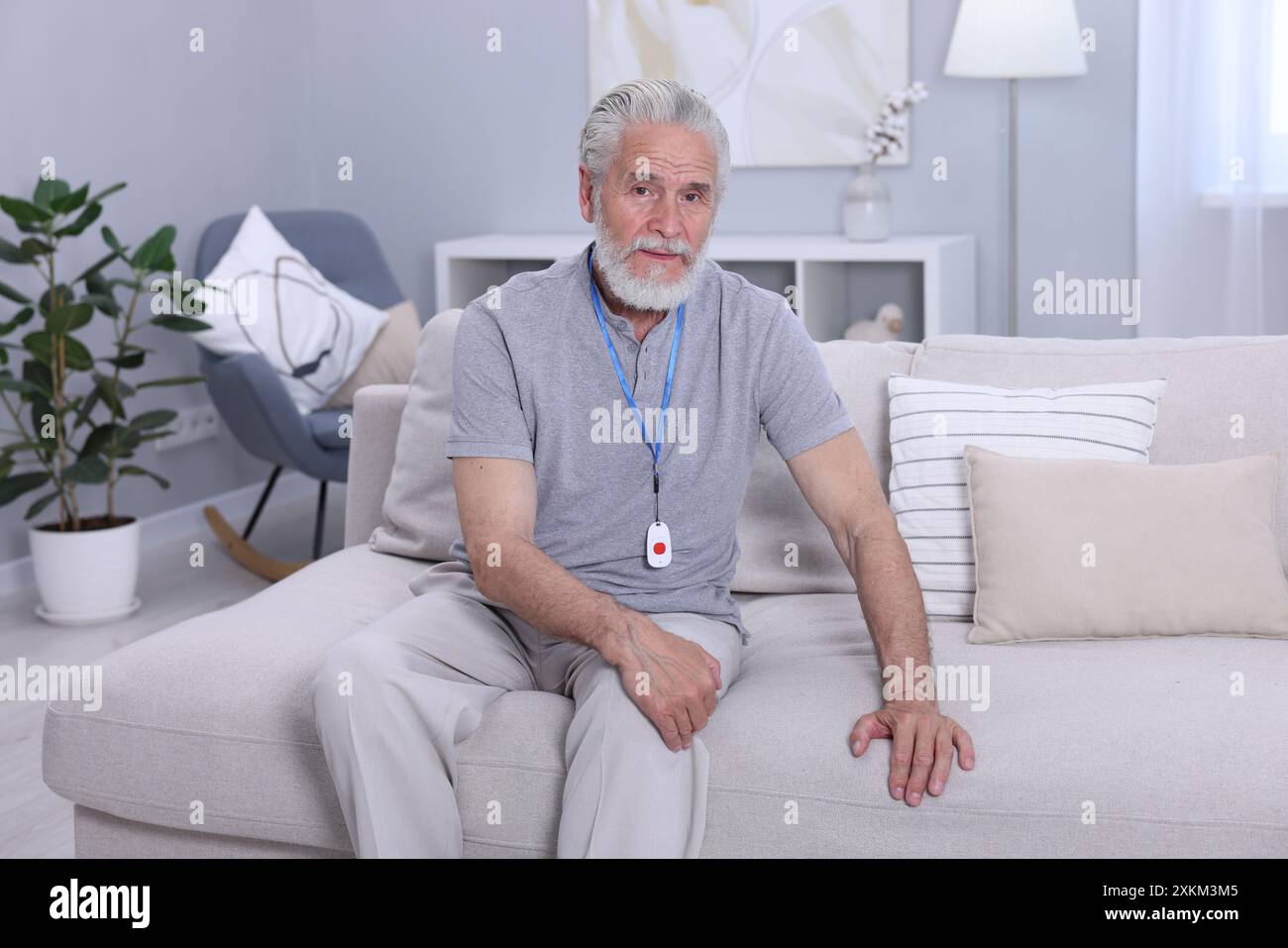 Senior Mann mit Notruftaste zu Hause Stockfoto