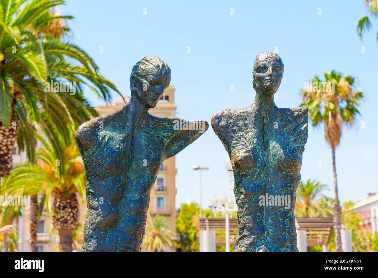 Barcelona, Spanien - 16. Juli 2024: Fesselnde Bronzeskulpturen eines Paares, das inmitten von Palmen steht und Beziehungen und Kunst im Herzen widerspiegelt Stockfoto