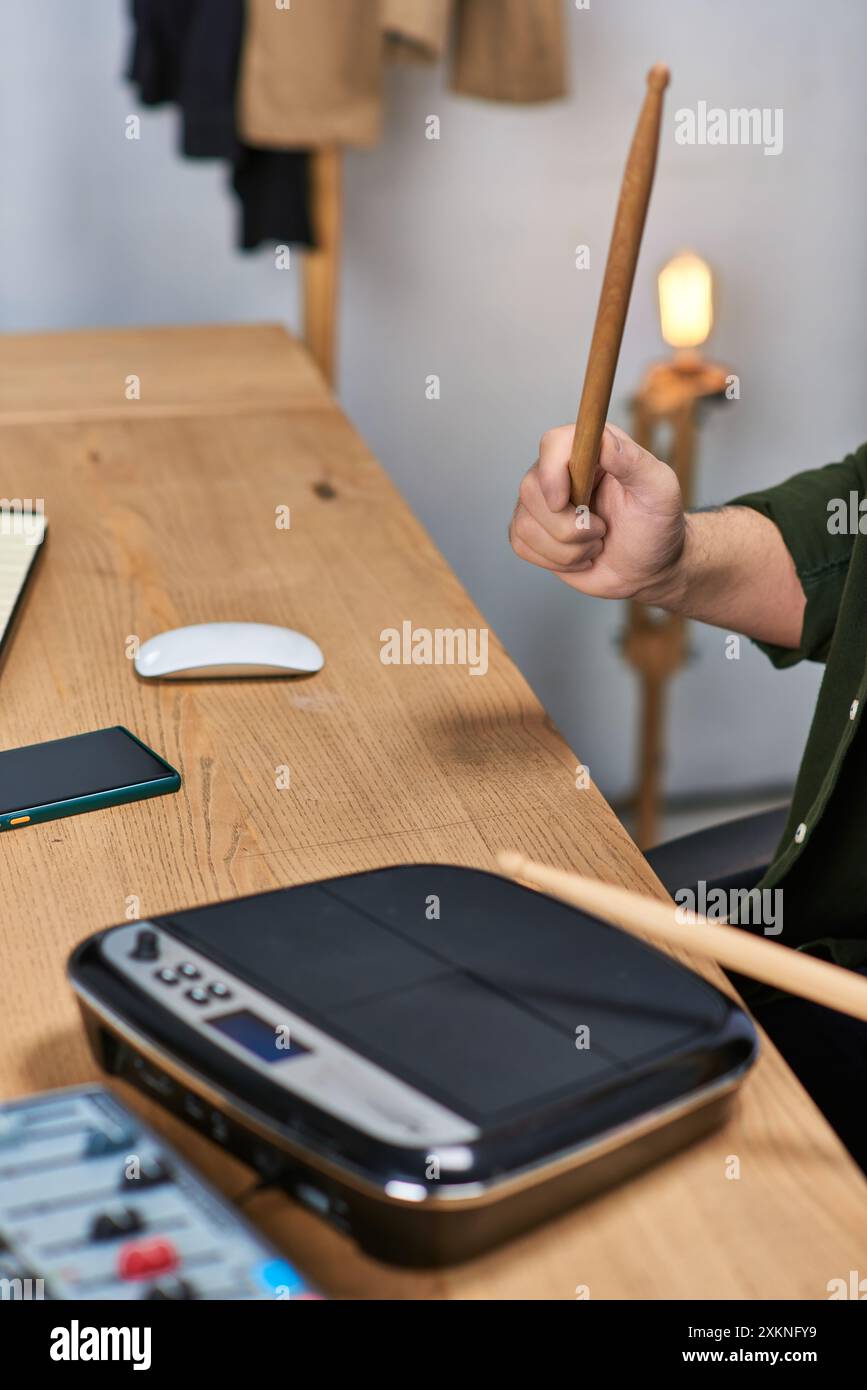 Ein asiatischer Mann spielt Schlagzeug in zwangloser Atmosphäre und zeigt sein musikalisches Talent. Stockfoto