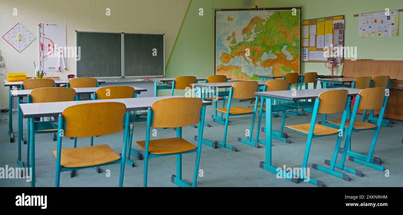 Leeres Klassenzimmer mit Kreidetafel und Karte im Hintergrund Stockfoto