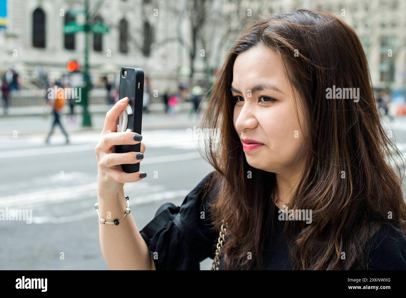 Junge asiatische Frau Junge asiatische Frau macht ein mobiles Foto gegenüber der New York Public Library. New York City, New York, USA. New York City Downtown, Manhattan New York Vereinigte Staaten von Amerika Copyright: XGuidoxKoppesxPhotox Stockfoto