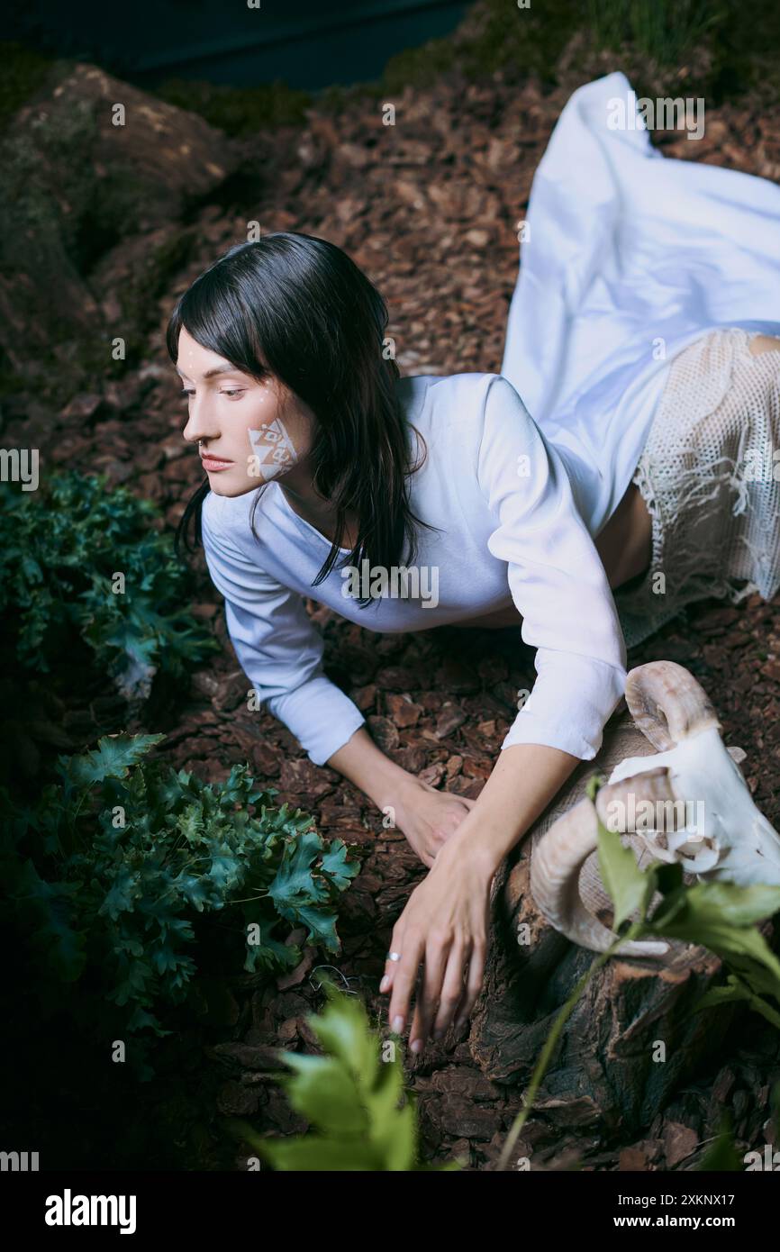 Frau in weißem Kleid posiert elegant im Wald. Stockfoto