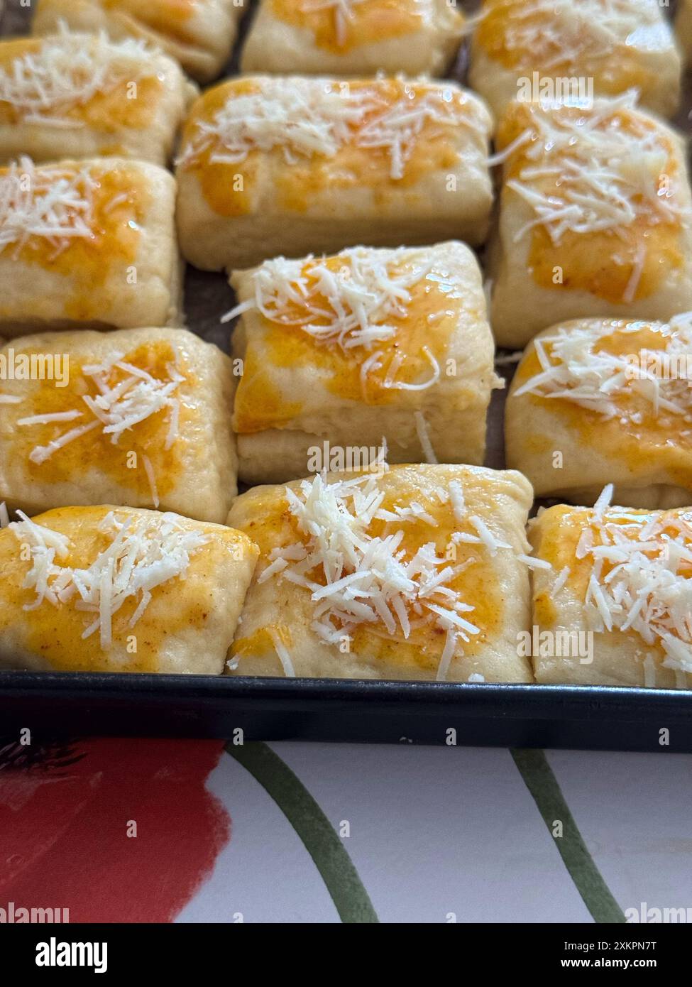 Nahaufnahme von frisch zubereiteten Brötchen mit Käse und goldener Kruste zum Backen Stockfoto