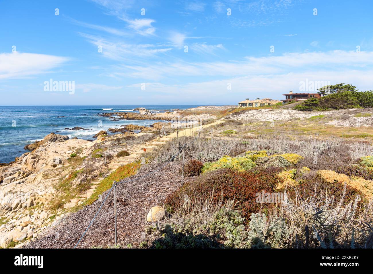 Häuser am Meer entlang eines einsamen Küstenweges an einem sonnigen Herbsttag Stockfoto