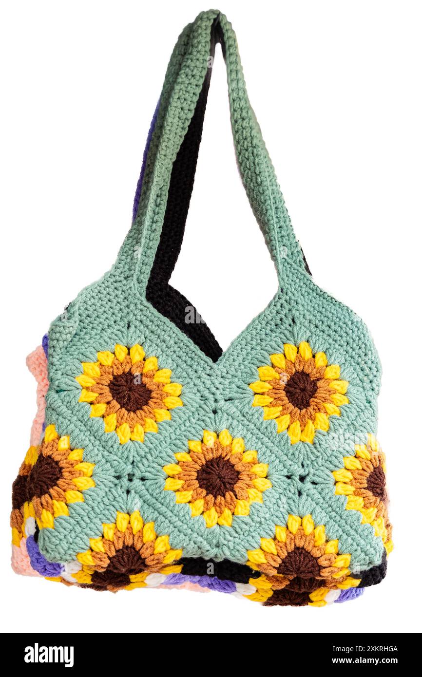 Gestrickte Tasche isoliert auf weißem Hintergrund. Handgefertigte Tasche mit Griff. Handgefertigte Strickhandtaschen für Damen, mit Blumenmuster und Quasten gestrickte Stricktaschen für Damen Stockfoto