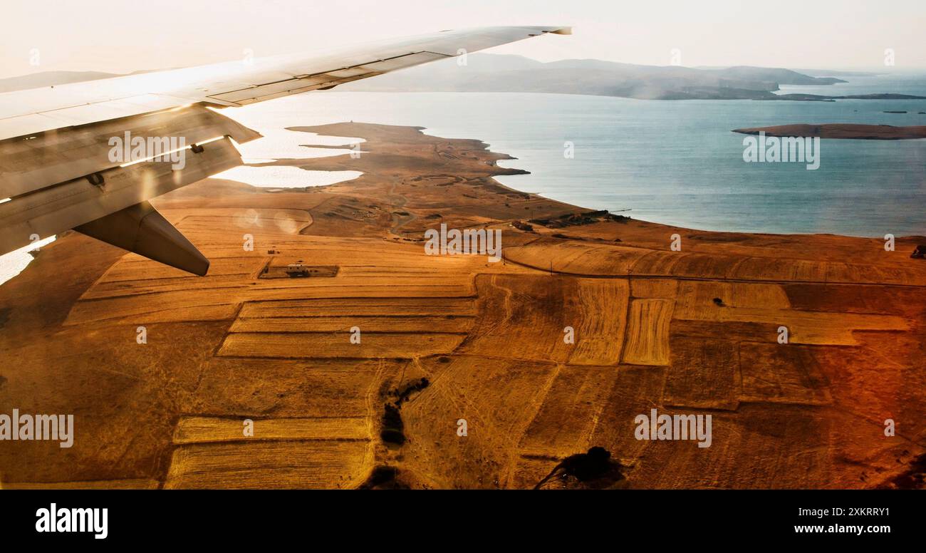 Aus der Vogelperspektive auf die Landschaft der Insel Limnos, das Meer und viele kleine Felder in der herbstlichen trockenen Landschaft vor der Landung. Griechenland. Stockfoto