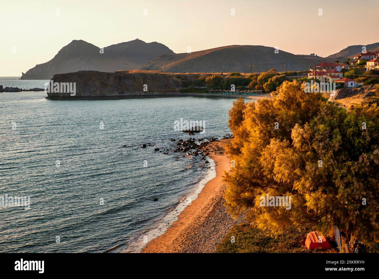 Malerische Bucht mit goldenem Baum und schwarzem felsigem Berg westlich der Insel Limnos, Griechenland. Stockfoto