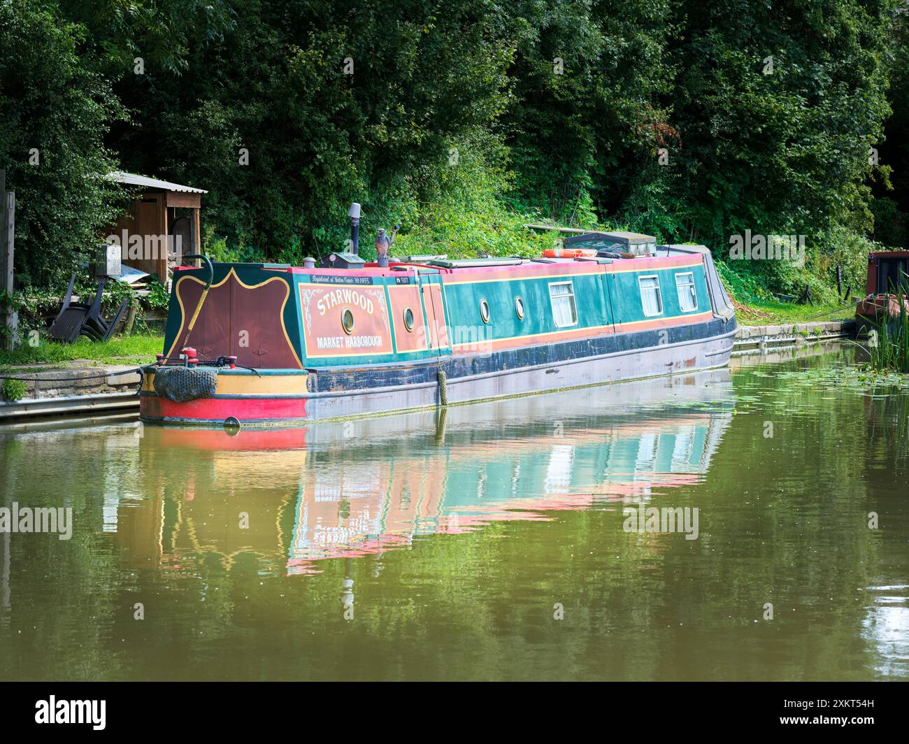 Ein Schmalboot, das an einem sonnigen Sommertag auf dem Market Harborough Arm des Grand Union Canal in Leicestershire, England, vor Anker liegt. Stockfoto