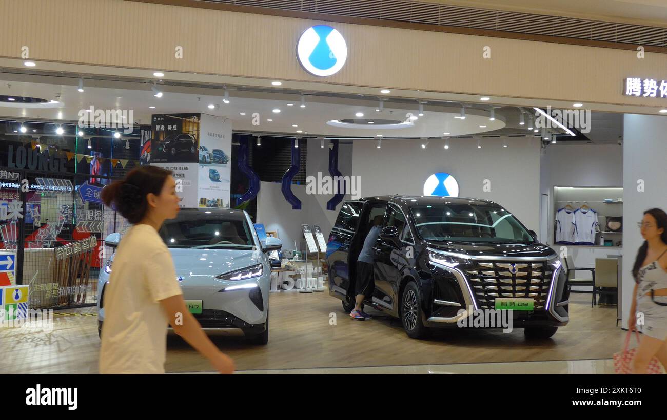 Fußgänger spazieren vorbei an der Autohersteller Denza in Shenzhen, China. Das ist ein Marken-Joint Venture zwischen BYD Auto Industry und der Mercedes-Benz Gruppe, die im Mai 2010 gegründet wurde. Stockfoto