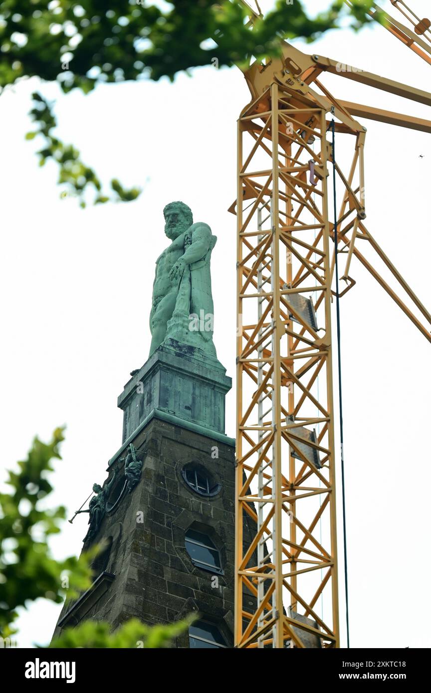 Kassel, Deutschland. Juli 2024. Kassels Wahrzeichen, der Herkules, steht neben einem Baukran. Als höchster Punkt des UNESCO-Weltkulturerbes bildet die Dauerbaustelle (seit 2006) das Ende des 1,5 Kilometer langen Kaskadenkomplexes. Quelle: Uwe Zucchi/dpa/Alamy Live News Stockfoto