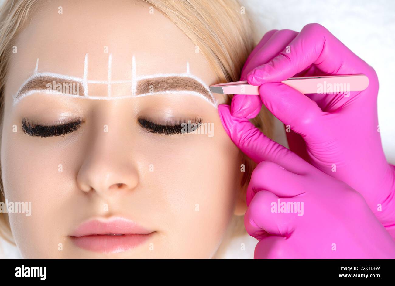 Frau mit Permanent Make-up Tattoo auf den Augenbrauen. Wimperntusche zupft die Augenbrauen mit einer Pinzette. Professionelle Make-up- und Kosmetikpflege. Stockfoto