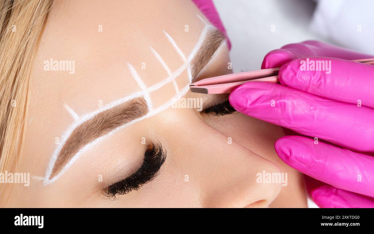 Frau mit Permanent Make-up Tattoo auf den Augenbrauen. Wimperntusche zupft die Augenbrauen mit einer Pinzette. Professionelle Make-up- und Kosmetikpflege. Stockfoto