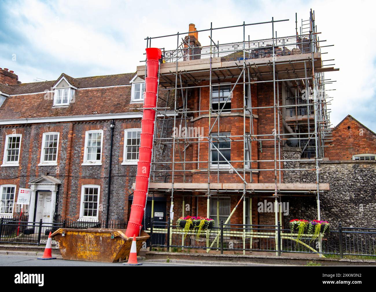 Historisches Gebäude in Marlborough Wiltshire wird renoviert, Gerüste und rote Schutt-Rutsche sind vorhanden, Bauarbeiten sind im Gange Stockfoto