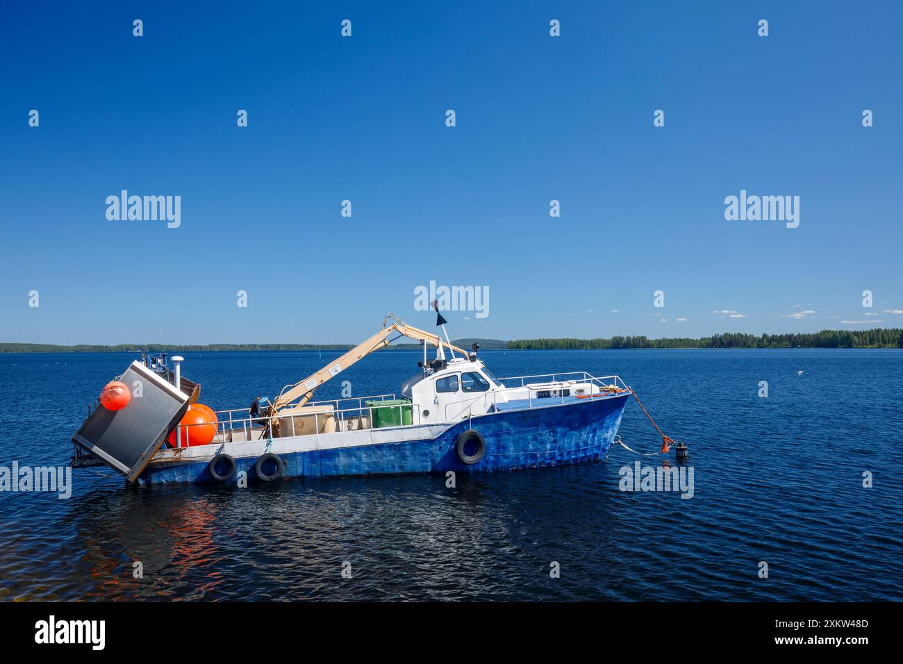 Kleiner finnischer Binnensee-Trawler, der hinter dem Seegang am See Pohjois-Konnevesi in Finnland ankert Stockfoto