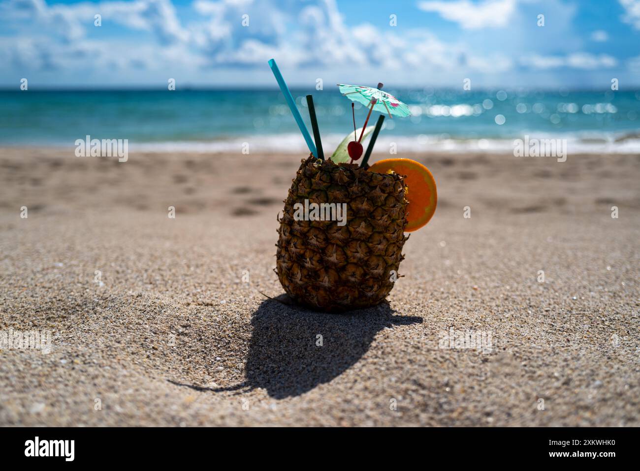 Exotische Ananas am Sandstrand in der Nähe des Meeres. Sommerurlaub. Tropisches Sommerkonzept. Freizeit im Sommer. Tropischer Strand. Strandparty. Pina Colada Stockfoto