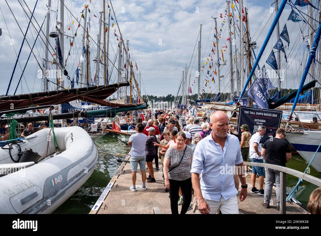 MARIEHAMN, Åland, FINNLAND - 24. JULI 2024: Besucher schlendern durch die 57 großen Schiffe, von denen viele besichtigt werden können. Tag 1 der dreitägigen Åland-Etappe des Tall Ships Race 2024 im Haupthafen, Mariehamn, Åland, Finnland. Foto: Rob Watkins/Alamy Live News. INFO: Das Tall Ships Race ist eine jährliche Segelveranstaltung mit historischen und modernen Großschiffen. Es fördert internationale Freundschaft und Jugendausbildung und zieht Teilnehmer und Zuschauer weltweit an, um maritimes Erbe und die Kunst des traditionellen Segelns zu feiern. Stockfoto