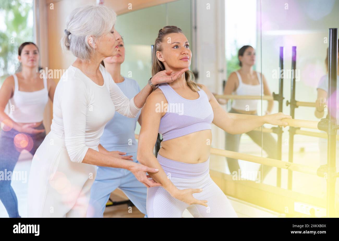 Ballettlehrerin, die die Schülerform in der Tanzschule anpasst Stockfoto