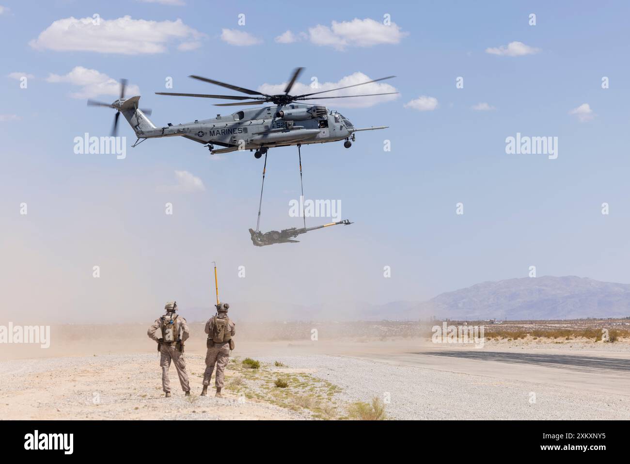 U.S. Marines mit Combat Logistics Battalion 2, Combat Logistics Regiment 2, 2nd Marine Logistics Group, beobachten Sie, wie ein Sikorsky CH-53E Super Hengst einen M777 Howitzer während des Hubschrauberunterstützungsteams im Rahmen der Integrierten Trainingsübung 5-24, auf der Landungszone Sandhill, Marine Corps Air Ground Combat Center Twentynine Palms, Kalifornien, hebt. Juli 2024. Ziel von ITX 5-24 ist es, eine anspruchsvolle, realistische Trainingsumgebung zu schaffen, in der kampfbereite Kräfte gebildet werden, die als integrierte Marine Air-Ground Task Force (MAGTF) eingesetzt werden können. (Foto des U.S. Marine Corps von Lance CPL. Jess Stockfoto