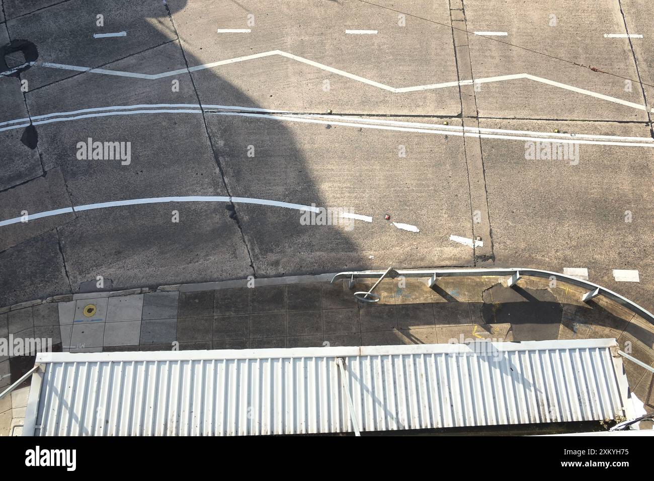 Draufsicht auf die Pfade aus Betonplatten und einer Reihe weißer Linien auf einer Inner West Road in Dulwich Hill, Sydney in der Nachmittagssonne Stockfoto