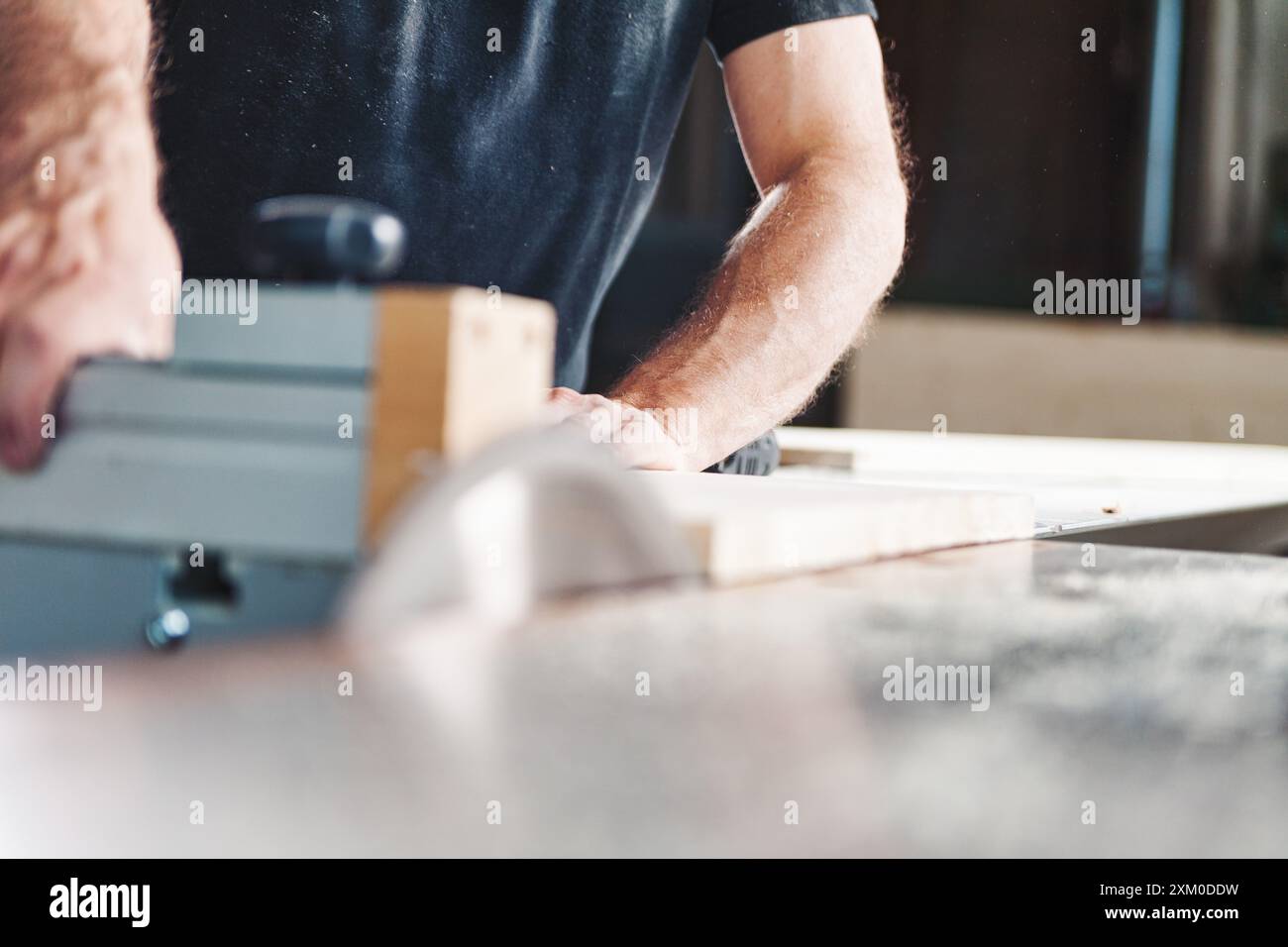 Erfahrener Zimmermann in einer Werkstatt, der Holzbearbeitungsmaschinen verwendet, um Holz präzise zu schneiden und Möbel und Designs zu kreieren Stockfoto