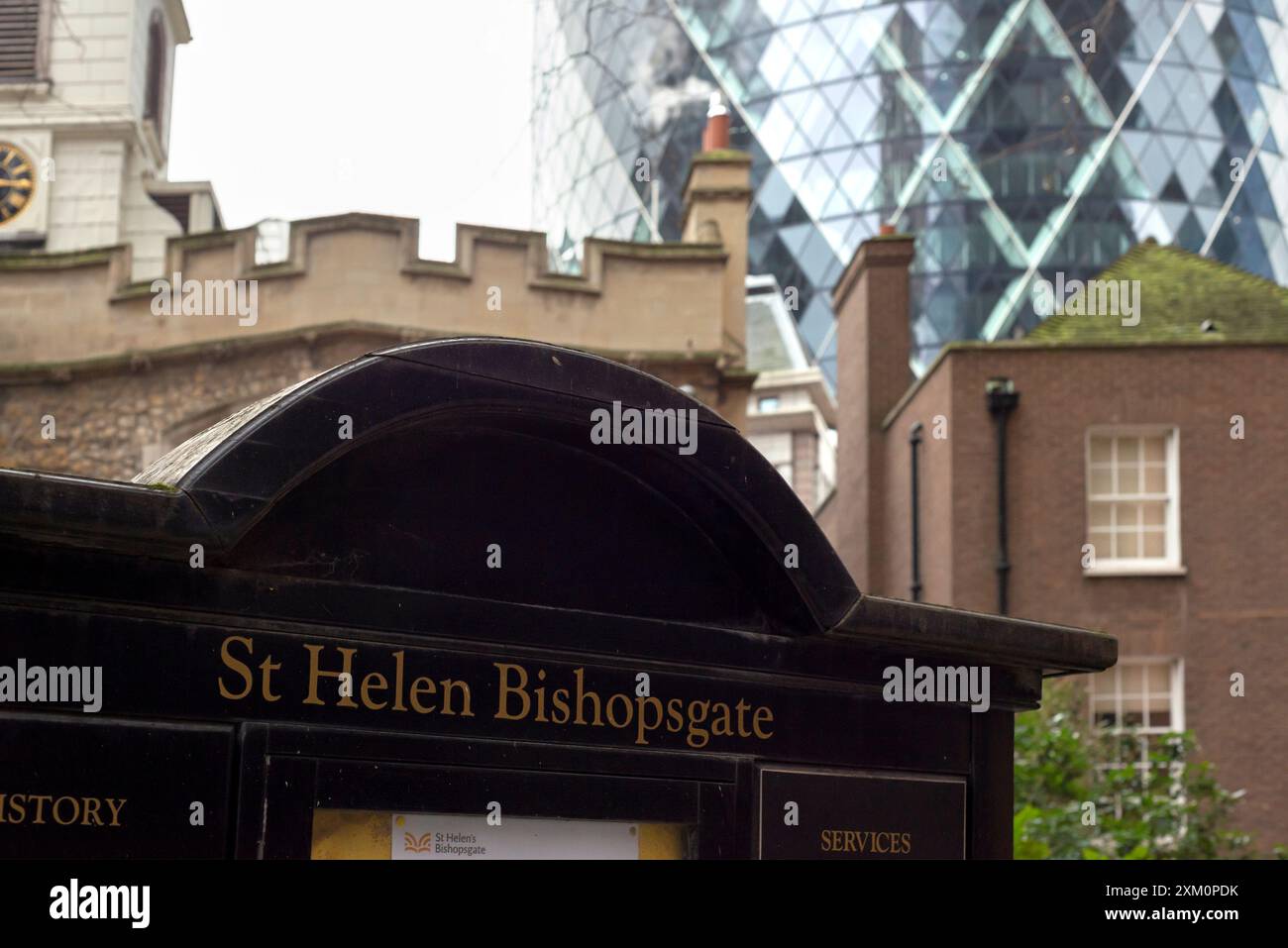 Die Kirche St. Helen's Bishopsgate steht im Vergleich zur St. Mary Axe aus dem Jahr 30 oder zum Gherkin-Gebäude in der City of London, Großbritannien. Altes und neues Nebeneinander-Konzept Stockfoto