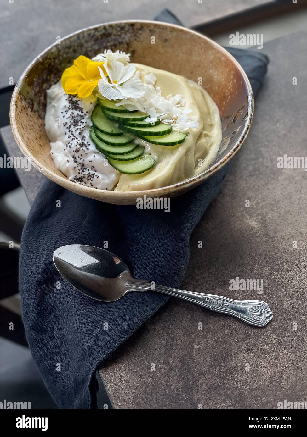 Banana Smoothie Schüssel mit Joghurt, Gurke, Kokosflocken und Chia, wunderschön dekoriert. Stockfoto